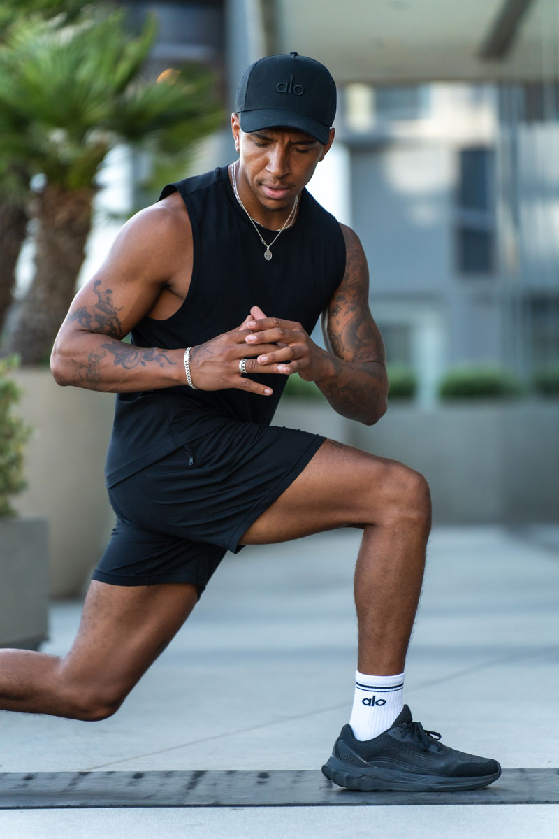 Coach is posing topless outdoors.
